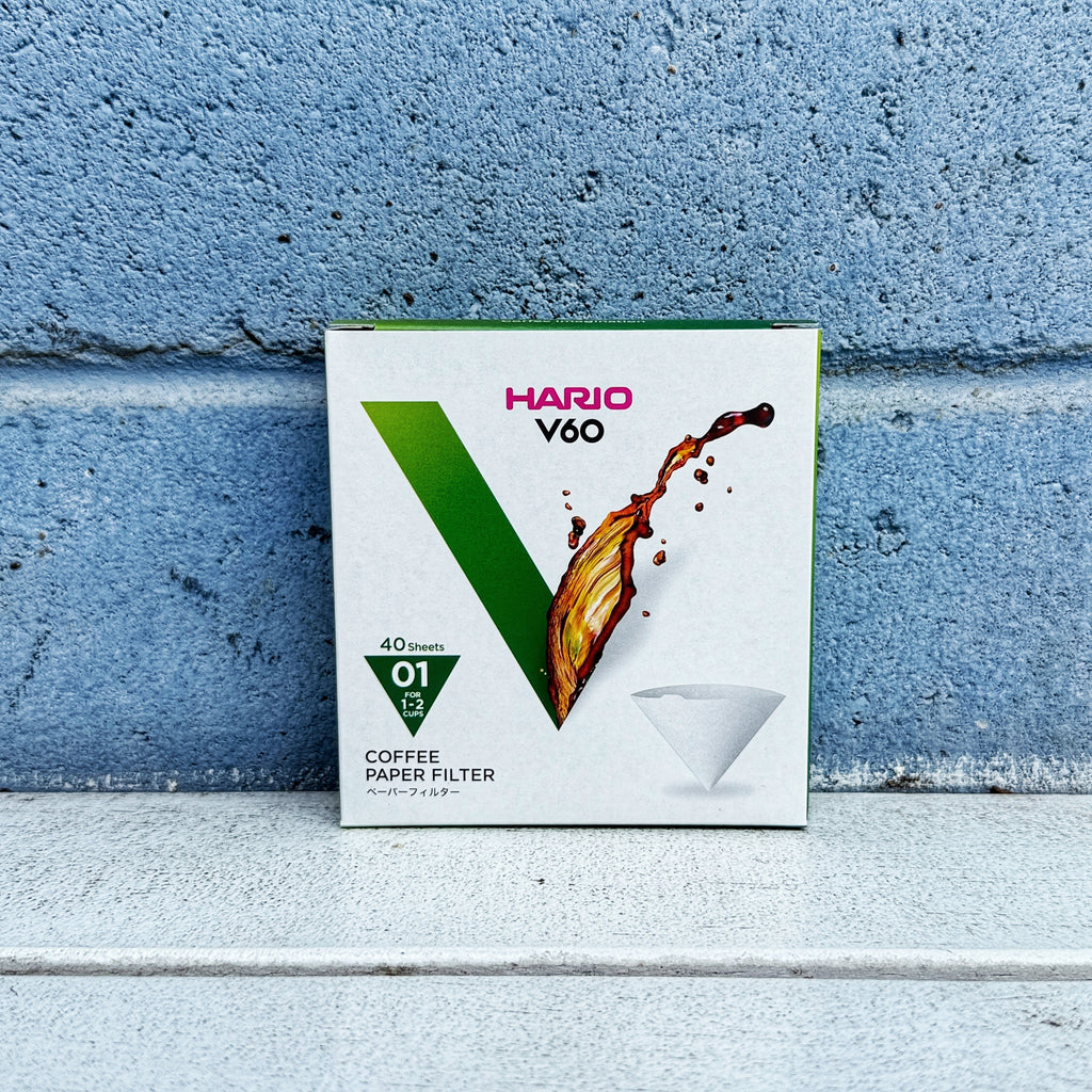 Hario V60 01 coffee filter box against a blue brick wall
